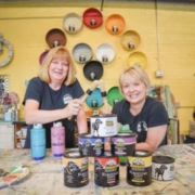 Laura and Swooz sit with Black Dog Salvage furniture paint in Black Dog Salvage's retail showroom