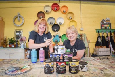 Laura and Swooz sit with Black Dog Salvage furniture paint in Black Dog Salvage's retail showroom