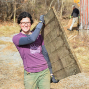 Grayson Goldsmith carries a piece of salvaged wood at the Taylor family farm