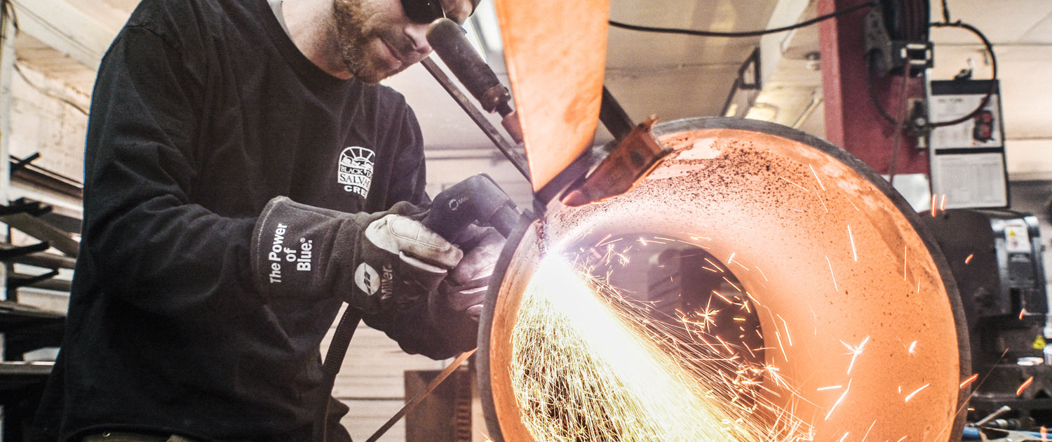 a man welds in the Black Dog Salvage Design Center